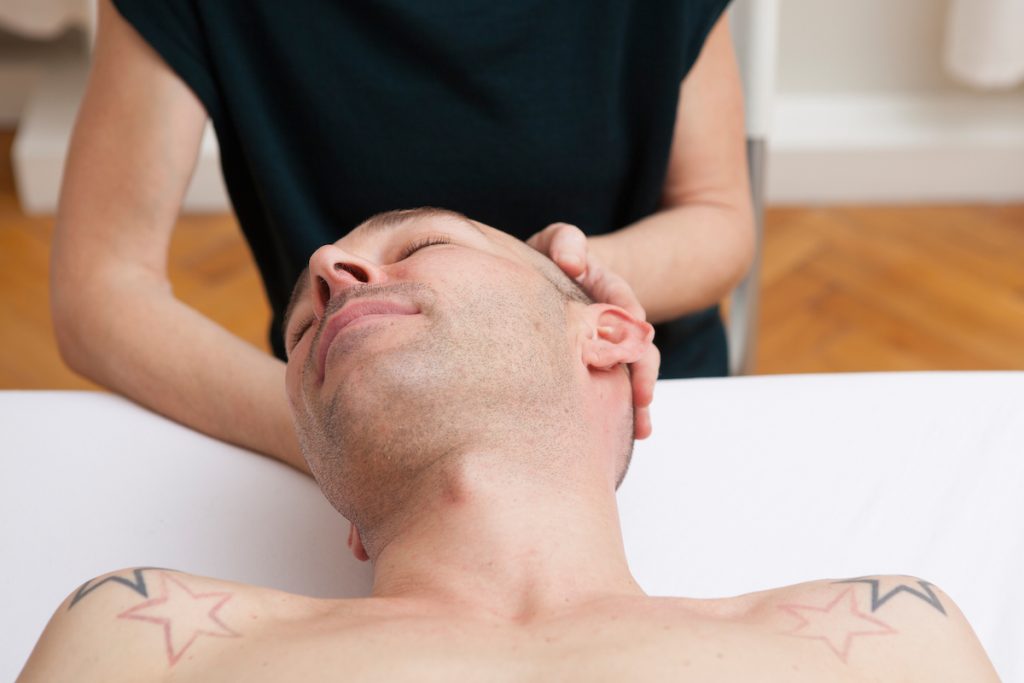 Zwei Hände, die den Kopf eines Kunden der Grinberg Methode in Wien halten