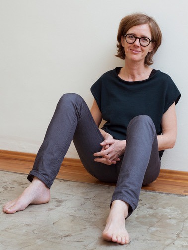 Rahel Baumgartner sitzt entspannt in ihrer Grinberg Praxis in Wien